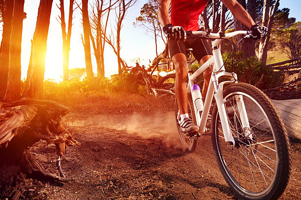 Close-up of a man on mountain bike riding on trail Mountain Bike cyclist riding single track at sunrise healthy lifestyle active athlete doing sport mountain biking stock pictures, royalty-free photos & images