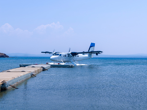 Seaplane in the sea. Seaplane docking at the pier in a bay in Bozcaada in the Northern Aegean, Turkey. Summer.