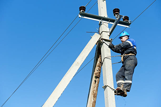 istock Electrical lineman working at the top of the pole 165574374