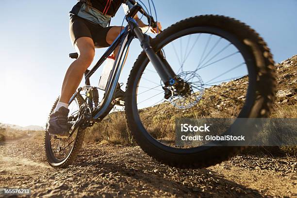 Man Riding Mountain Bike En Un Día Soleado Foto de stock y más banco de imágenes de Lodo - Lodo, Motociclista, Actividad