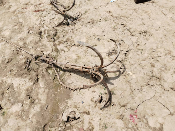 istock Fishing boat rusty traditional anchor on a beach by the river. 1655780781