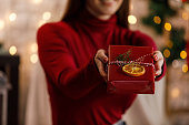 Caring young woman giving you a rustic Christmas gift box for holidays