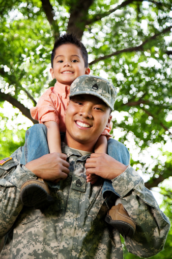 Young American soldier and son in a park.