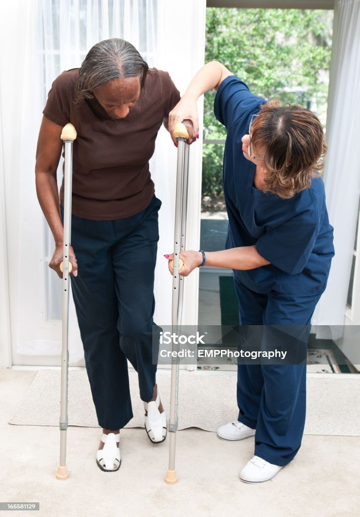 Senior African American Woman getting help with Crutches Crutch Stock Photo