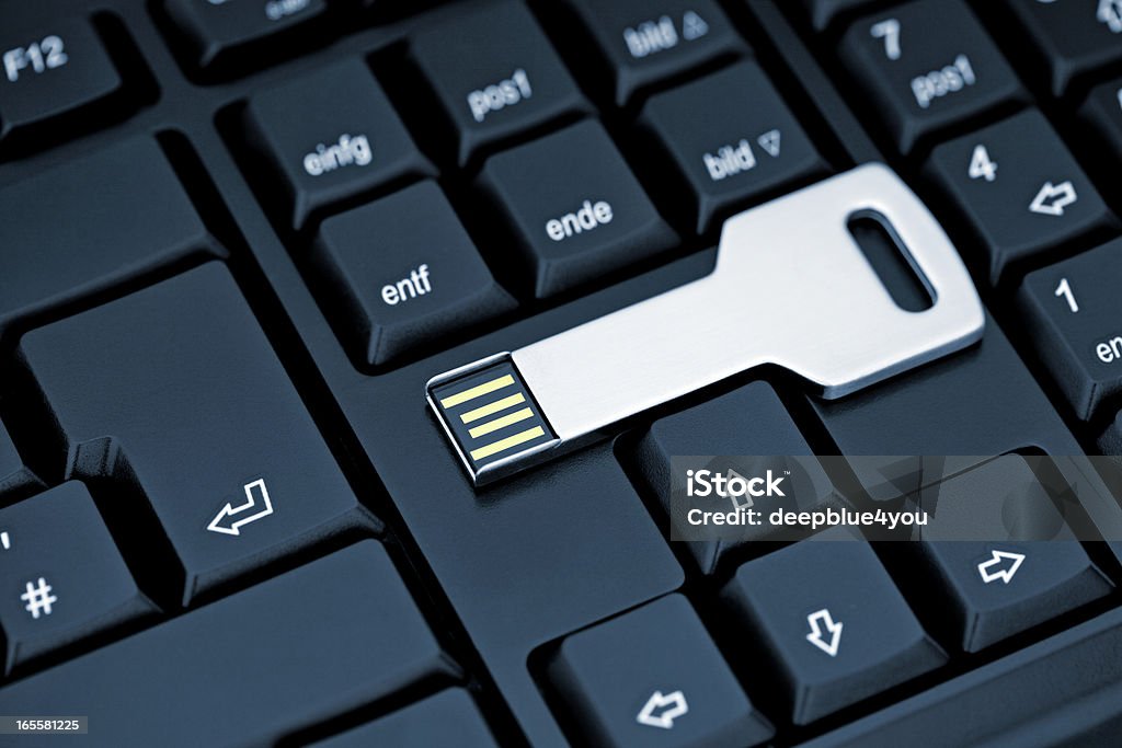 Metal USB flash storage Key on black Keyboard USB Stick Key on Keyboard Security Stock Photo