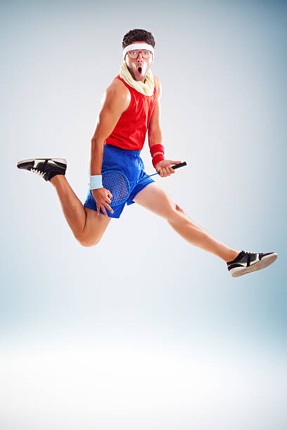 Fitness man jumping with tennis racket stock photo