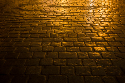 close-up of a cobbled road in the city light, at night