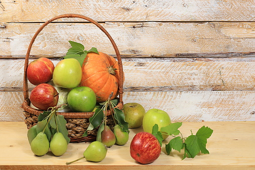 Fresh fruits in a wicker basket on a white background