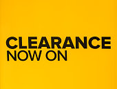 Yellow clearance sale sign in retail store. Clearance sign in a clothing store. Seasonal discount offer in store