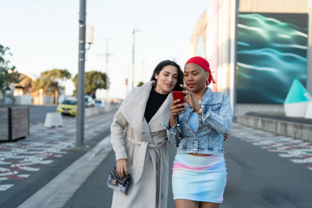 istock friends walking and using smart phone 1655988518