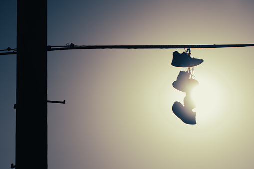 Shoes hang from a telephone wire.