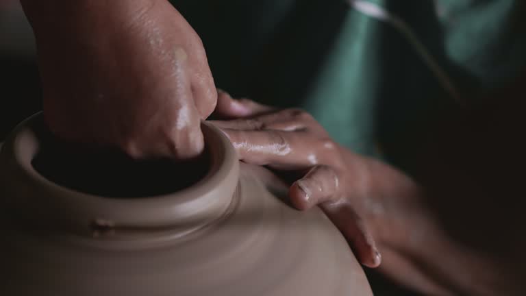 Close up, Hard-working man potter making clay vessel with hands