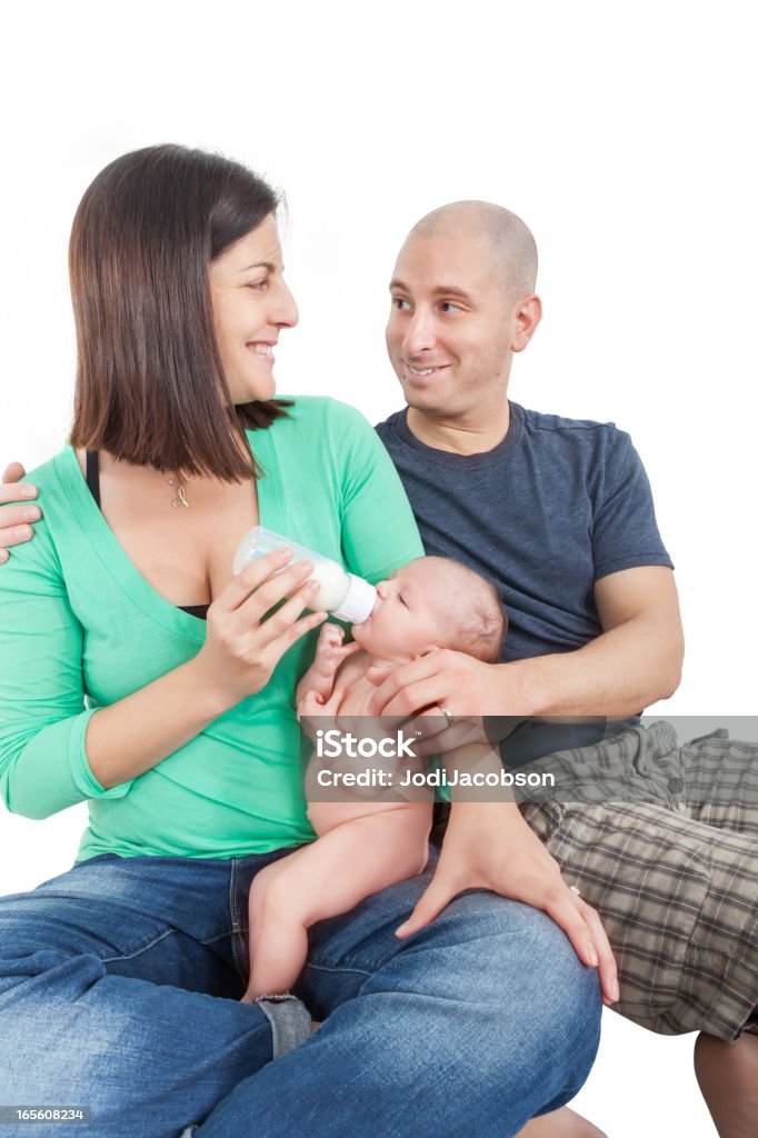 A young couple feeding their infant. Mother and father in their 30's with a 4 month old 25-29 Years Stock Photo