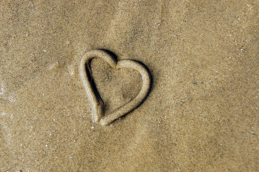 Heart on the sand. Sea love concept. Copy space.