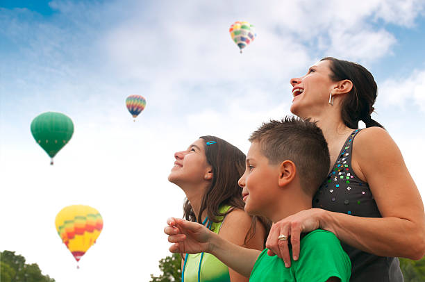 familie mit heißluftballons - balloon child people color image stock-fotos und bilder