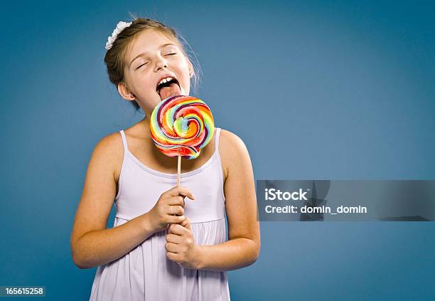 Foto de Jovem Feliz 9 Anos De Idade Com Pirulito Na Azul e mais fotos de stock de Menina - Menina, Lamber, 8-9 Anos