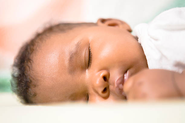 A cute baby girl fast asleep taking a nap stock photo