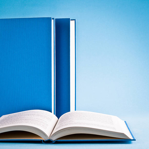 istock Open book and books in raw isolated on blue background 165615548