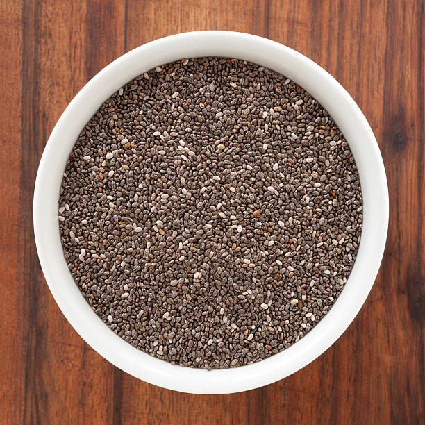Chia seeds Top view of white bowl full of chia seeds chia seed photos stock pictures, royalty-free photos & images