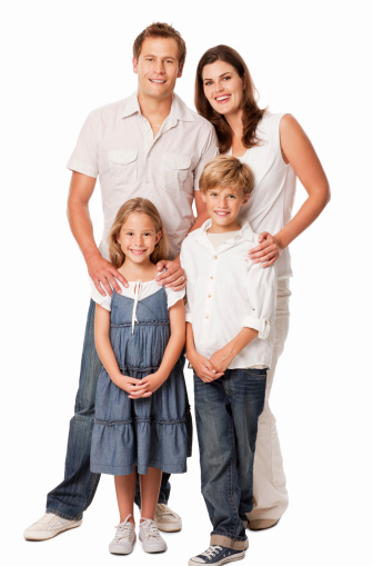 Full length portrait of parents stand behind their two children with their hands on their shoulders. Vertical shot. Isolated on white.