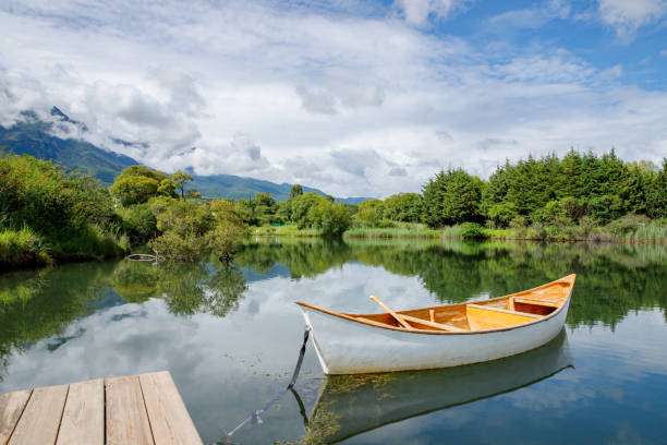 istock a lone canoe on shore at a peaceful lake at sunset. 1656180624