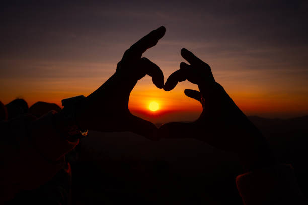 istock Hands forming a heart shape with sunset silhouette.Silhouette hand gesture feeling love during sunset 1656182091