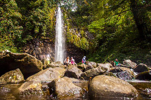 Tourist enjoying the beauty of Lembah Anai Waterfall, a nature tourist destination in Padang, West Sumatera, Indonesia.