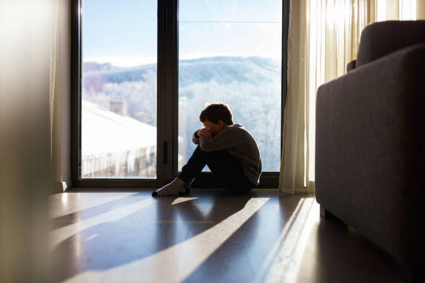 istock Depressed boy sitting in the room 1656183211