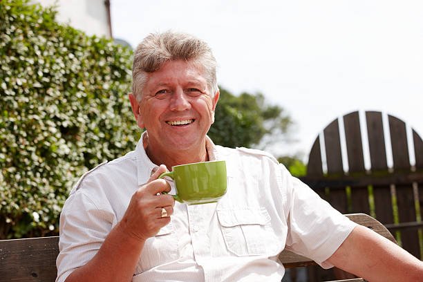 istock Senior man outdoors drinking coffee from green mug 165619166