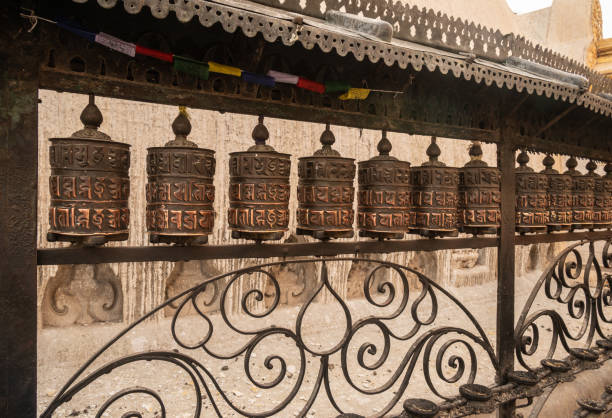 file di ruota di preghiera nel tempio di swayambhunath nella città di kathmandu del nepal. - prayer wheel immagine foto e immagini stock