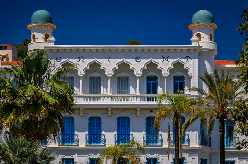 Menton, France - May 26, 2023: Orient Palace, a magnificent building of a former hotel now turned apartment building with a splendid garden