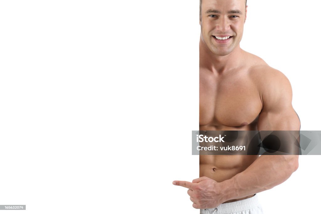 Presentation Muscular guy shows with hand on empty advertisement panel-isolated on white background Males Stock Photo