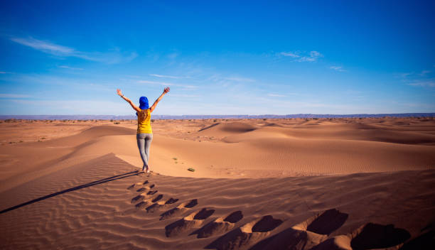 サハラ砂漠の砂丘の上の女性 - desert landscape morocco sand dune ストックフォトと画像