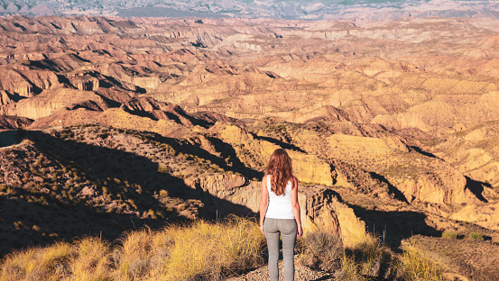 Woman looking at the desert landscape- travel, loneliless,adventure or wanderlust concept