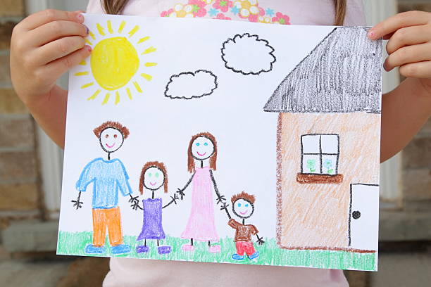 Girl Holds Drawing of Her Family A four year old girl displays her drawing of her family standing outside of their beautiful new home.  The family includes a father, daughter, mother, and son all holding hands.  The drawing also includes a bright sun, clouds, and a house. crayon photos stock pictures, royalty-free photos & images