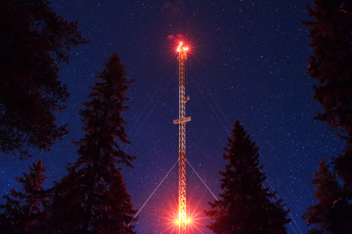 Communications tower and old spruce trees (Picea abies) against starry night sky. 15 sec exposure with ISO 6300 (Nikon D3).
