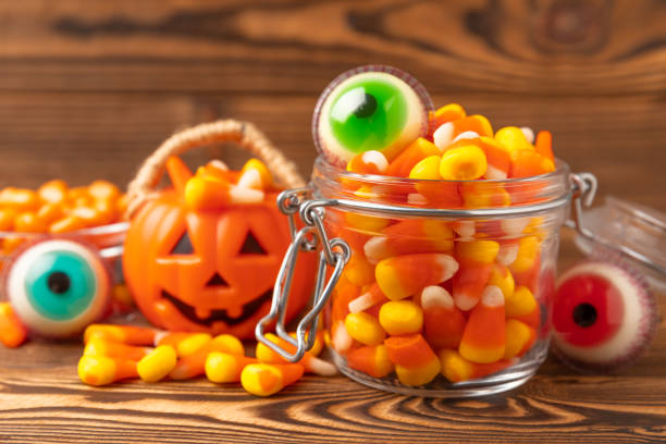 istock Halloween candy corn,jelly eye, pumpkin candy, sugar skull in different bowls on white background.Classic candy sweets for Halloween with.Halloween holiday concept with candy corn and jack o lantern. 1656362332