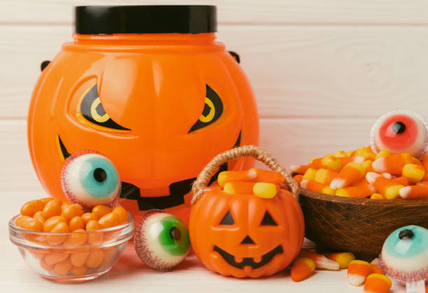 istock Halloween candy corn,jelly eye, pumpkin candy, sugar skull in different bowls on white background.Classic candy sweets for Halloween with.Halloween holiday concept with candy corn and jack o lantern. 1656362520