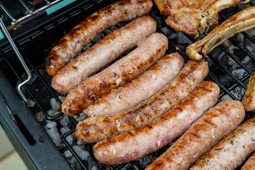 Flame-grilled sausages on a barbecue grill, appetizing and mouthwatering.