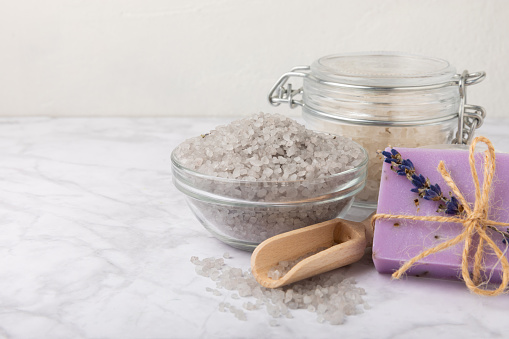 Lavender spa.Essential oils,sea salt,body scrub,lavender flowers and handmade soap.Natural herbal cosmetics with lavender flowers on brown texture wood.Relax concept.Beauty treatments.Copy space.