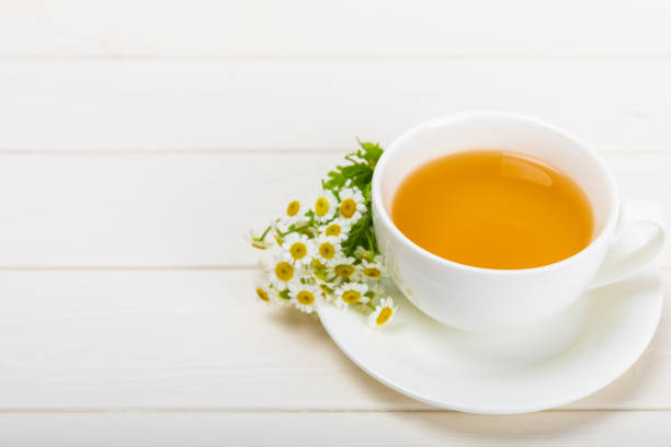 istock Chamomile tea in a  cup on a  texture background. Natural hour with chamomile flowers. Herbal tea. Immunity tea.Natural healer concept. Healthy detox drink.Close up. Place for text. 1656410654