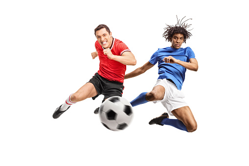 African american and caucasian football players jumping and kicking a ball isolated on white background