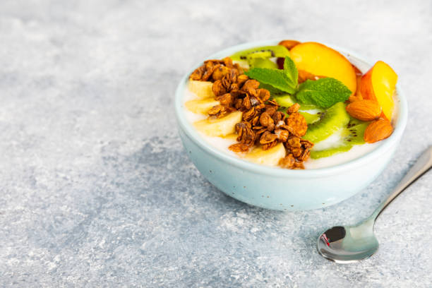 istock Granola bowl with yogurt and fresh almonds, blueberries, raspberries,peach and strawberries on a  kitchen table.Acai and spirulina bowl.Healthy breakfast concept.copy space.Place for text. 1656422869