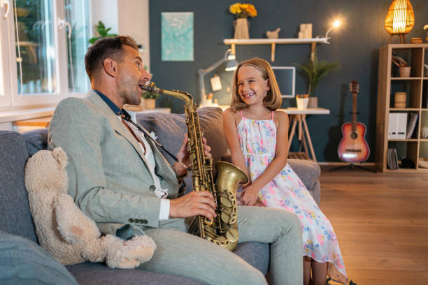 istock Father playing saxophone while his daughter listening to him 1656439573