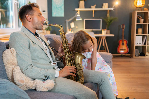 istock Father playing saxophone while his daughter listening to him 1656439872