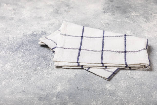 istock Kitchen towel on a  textured background. Kitchen utensils and textile napkin. A stack of cotton towels on the table. Home decor. Tablecloth for the table. Copy space for text. Mockup for design. 1656447496