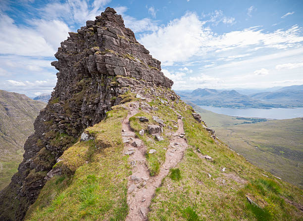 You Take The High Road A fork in the footpath ahead of a steep pinnacle on the Scottish mountain of Beinn Alligin, one of the most prominant of the Torridon Mountains in the north west of Scotland.  The pinnacles along the ridge are also known as the Horns of Alligin. steep stock pictures, royalty-free photos & images