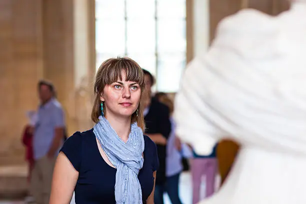 Photo of Woman in museum looking at fine art statue