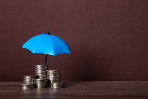 istock Blue umbrella and the stack of coins. 1656501508