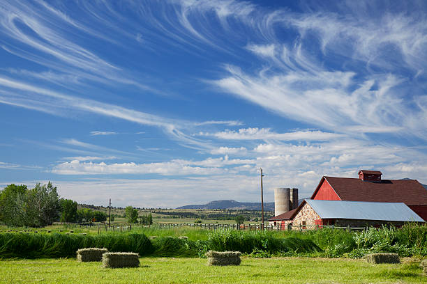 Boulder Colorado Red Barn and Cloudscape A red barn in Boulder Colorado, surrounded by Hay Bales and under a dramatic blue sky with awesome clouds. red barn house stock pictures, royalty-free photos & images